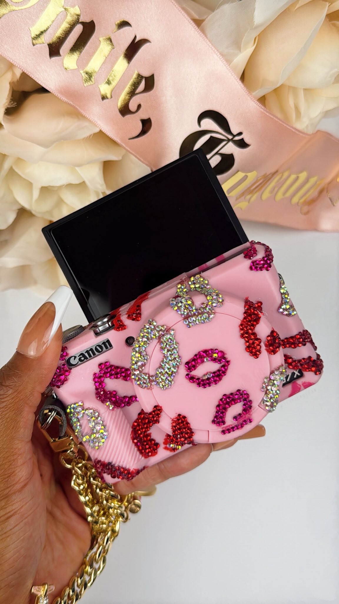 Here’s how I bedazzled my pink camera case and made the charm bracelet wrist strap for my @canonusa G7X Mark III 📸💖✨ I linked everything I used on ShopMy 🛍️ (in my bio).

Products Used:
💖 pink lips silicone camera case | @amazon 
💖 ss6 & ss10 pink, red & ab crystal glass flatback rhinestones | amazon
💖 sil-poxy silicone rubber adhesive | amazon
💖 spilt o ring adapter & leather cover | amazon
💖 gold purse wrist strap | amazon
💖 charm bracelet charms | @michaelsstores & @hobbylobby 

—
#flyfiercefab #canon #canong7xmarkⅱi #canong7x pink camera case, Canon camera case, Canon G7X camera case, canon camera accessories, Canon G7X camera accessories, pink aesthetic, black style influencer, DIY charm camera wrist strap, Canon G7X wrist strap, Rhode Island influencer, Boston influencer